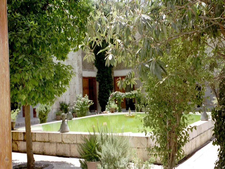 The pool and planted courtyard of the Bimaristan of Nur al-Din in Old Damascus, seen through a doorway