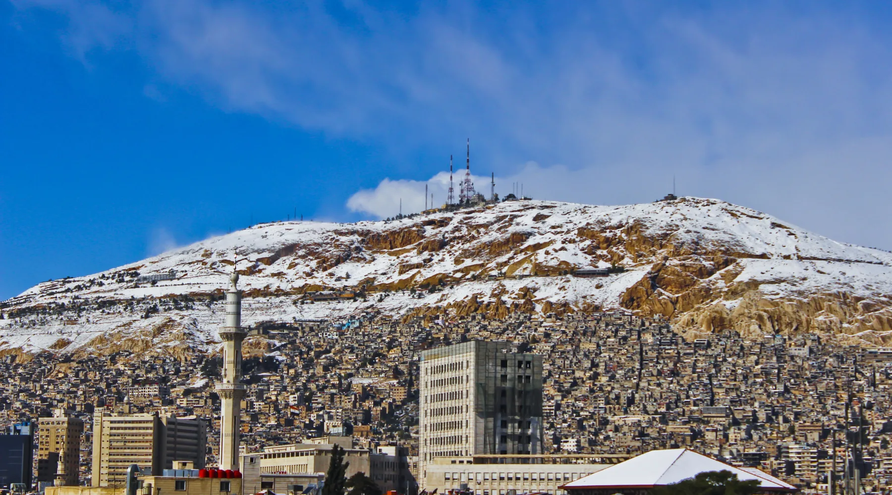 Snow on the ridge of Mount Qasioun above the rooftops and minarets of Damascus