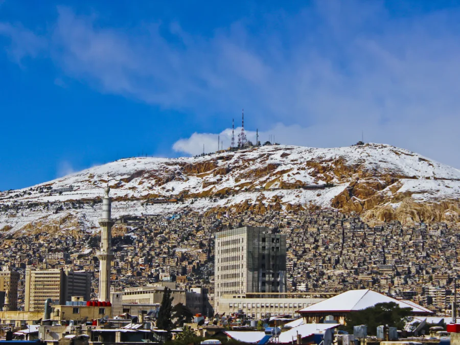 Snow on the ridge of Mount Qasioun above the rooftops and minarets of Damascus