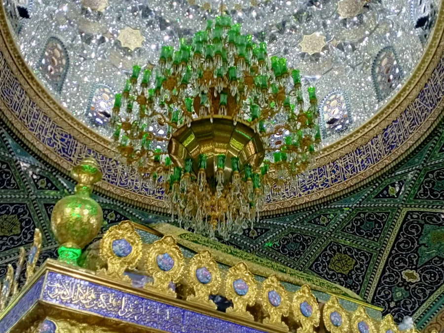 The mirrored dome and green glass chandelier above the gilded tomb screen in the shrine of Sayyida Ruqayya, Damascus