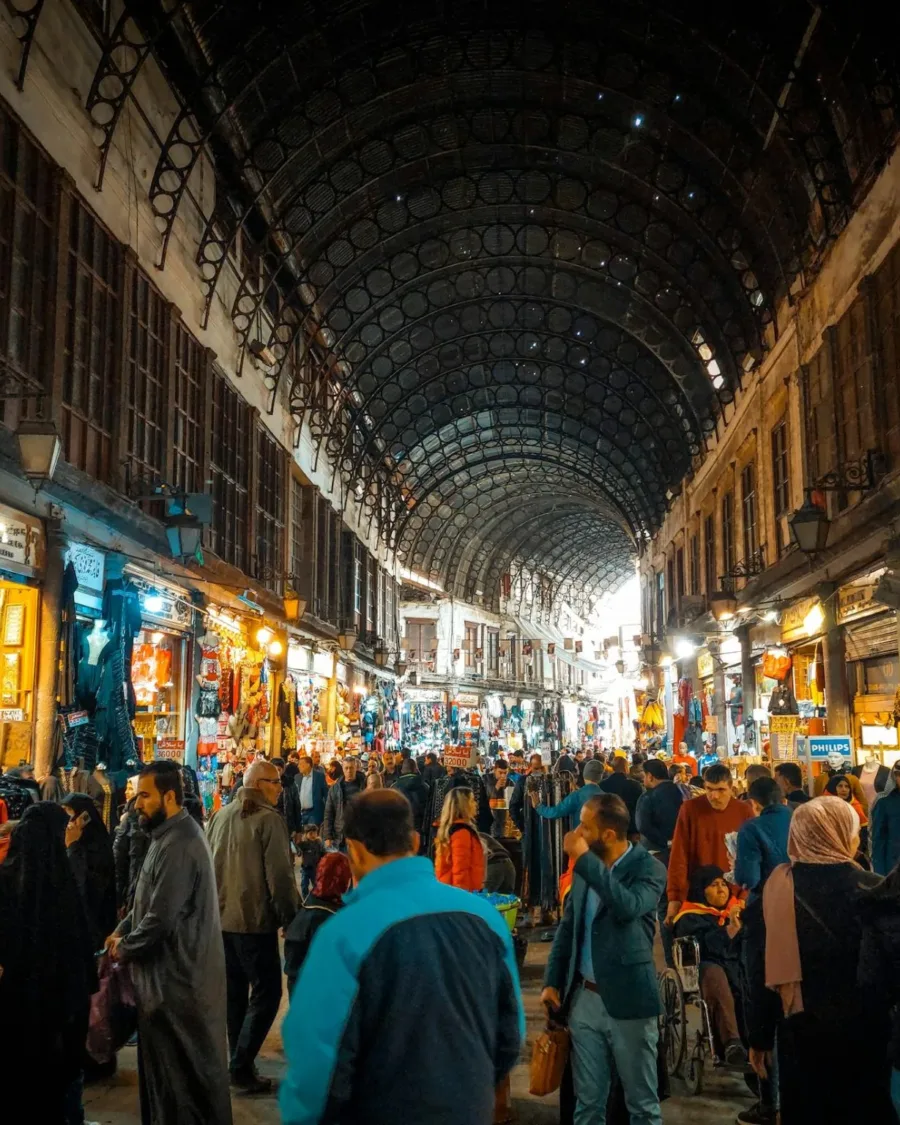 Shoppers beneath the arched iron roof of Souk al-Hamidiyah in Damascus
